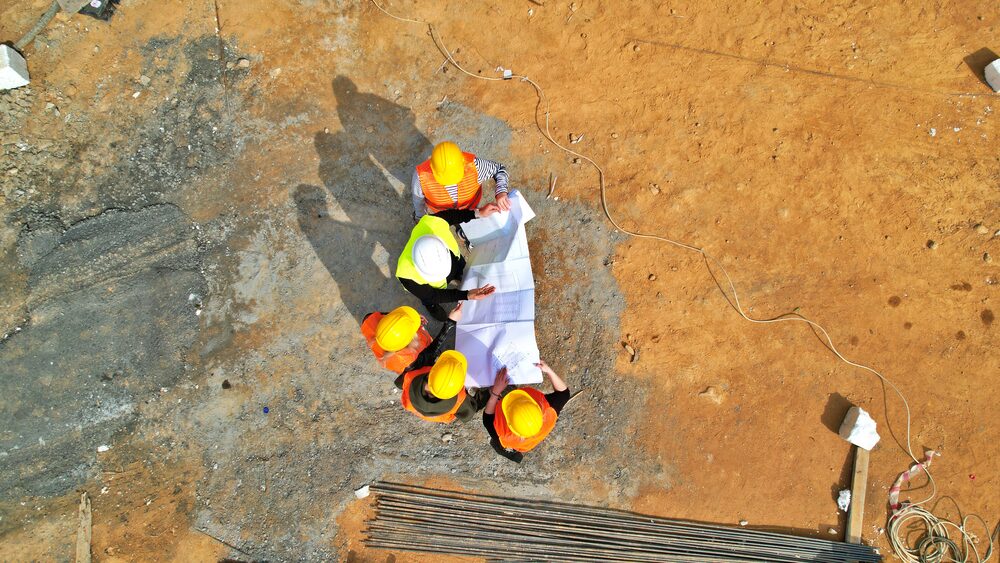 Sahada projeleri inceleyen mühendislerin havadan görünümü